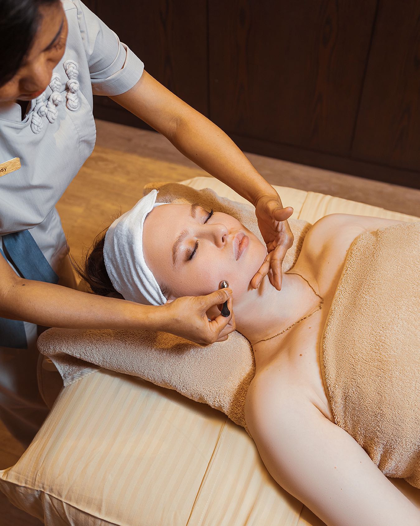 Therapist working along a client’s cheek with a small handheld tool.